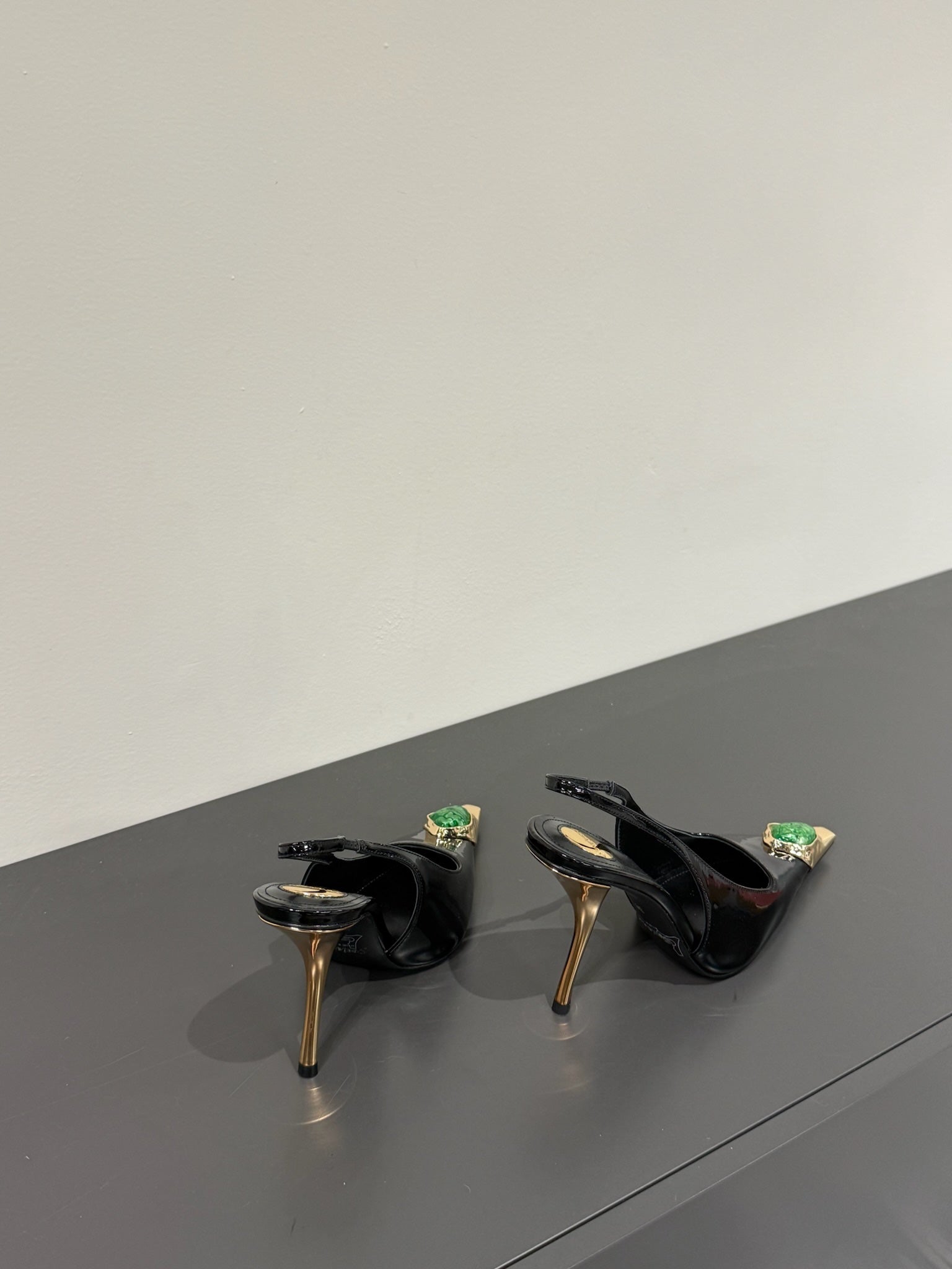 GREEN GEM-STUDDED SLINGBACK PUMPS IN BLACK PATENT CALFSKIN